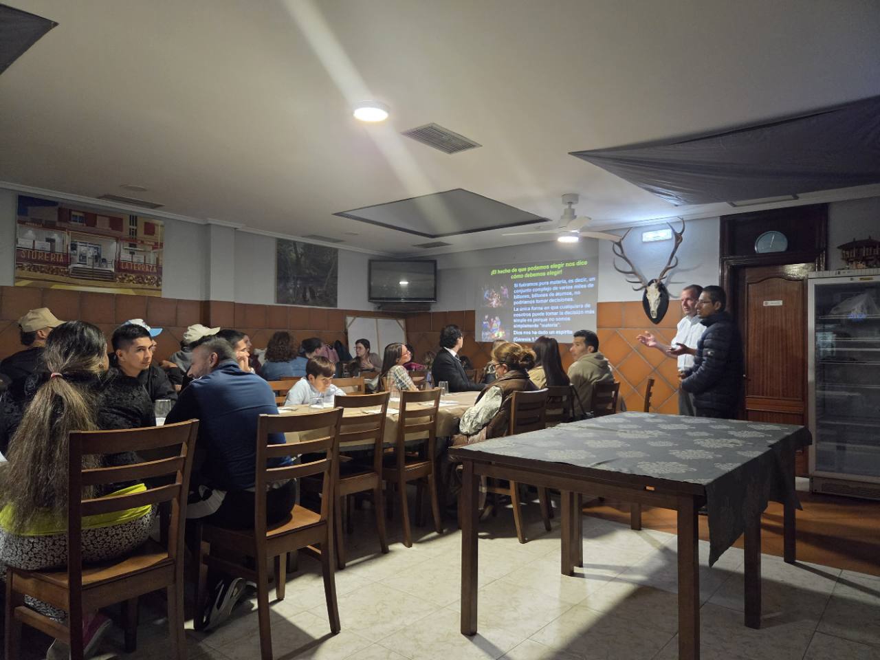 Personas reunidas alrededor de mesas durante una charla